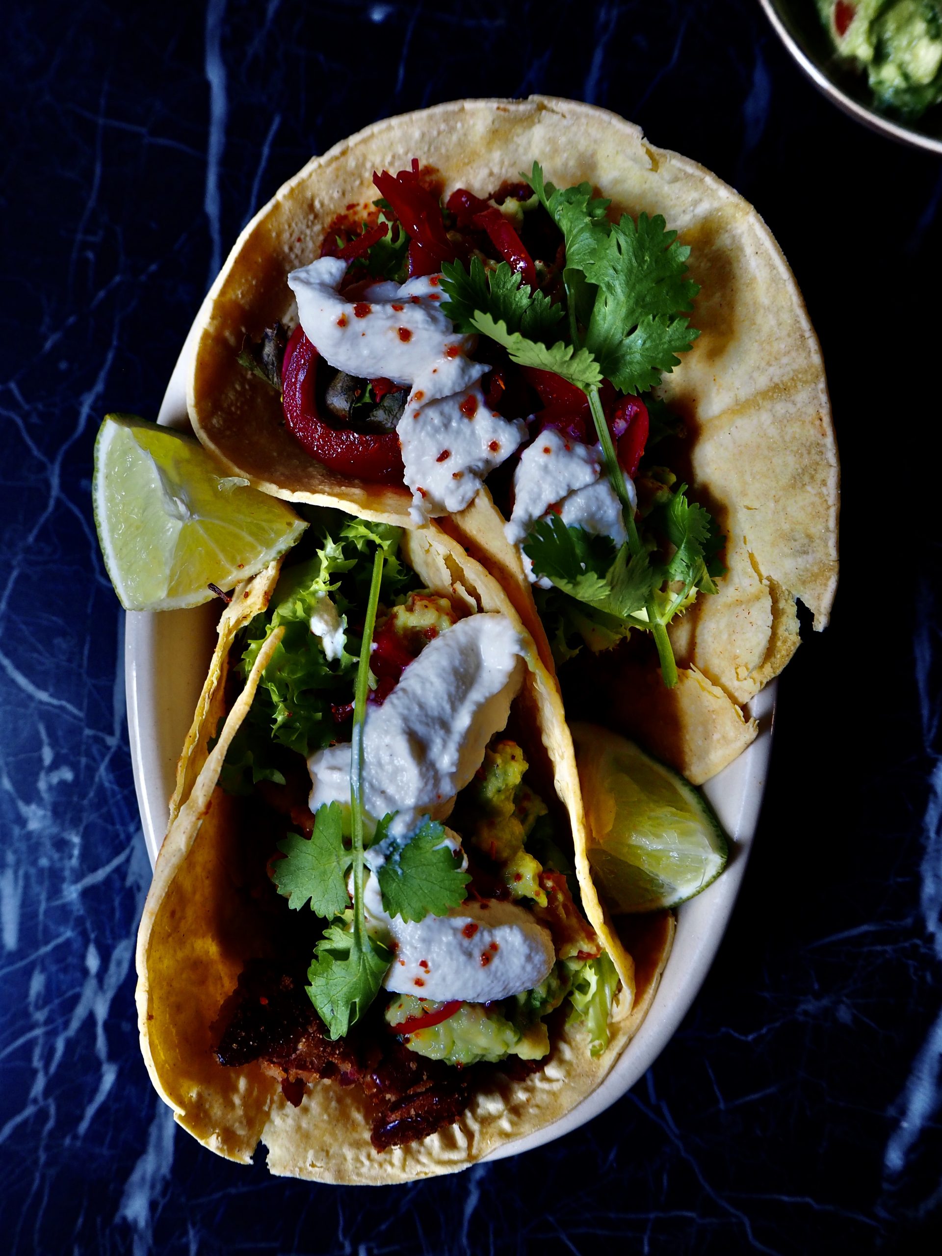 vegan tacos met bonen van bovenaf gezien tegen een donkere achtergrond