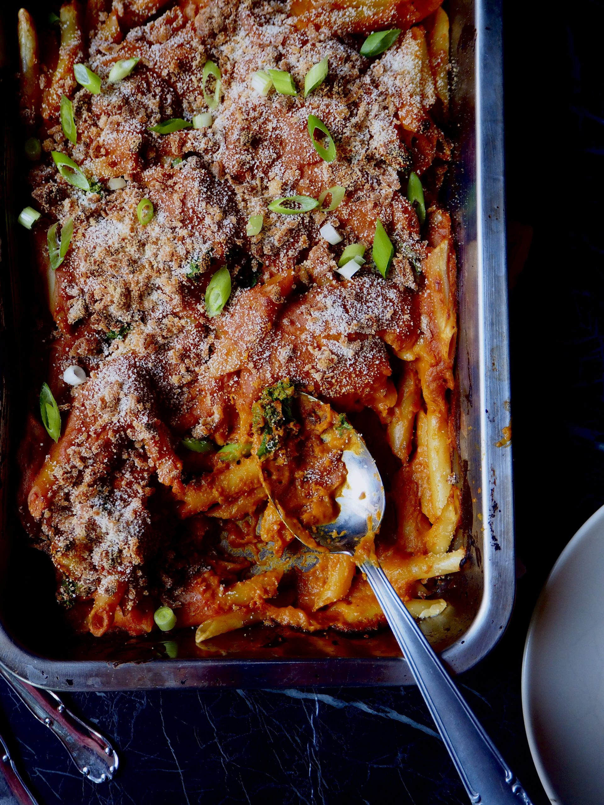 booze vegan mac 'n cheese seem from above with a serving spoon in the right bottom corner