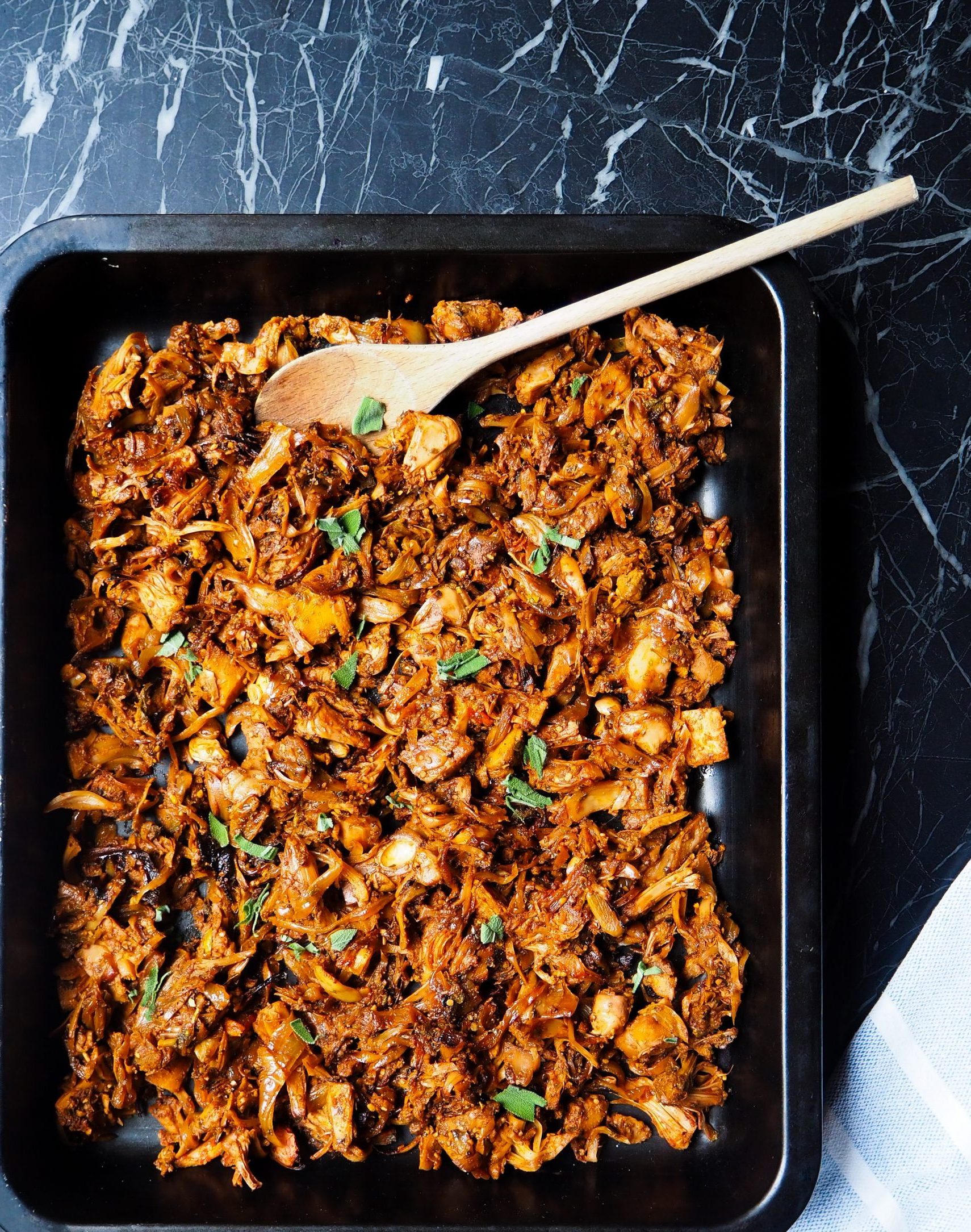 de eenpans bbq-salie jackfruit van bovenaf gezien met een houten lepen