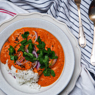 vegan butter chicken curry seen from above against a white back drop with silver vintage cutlery